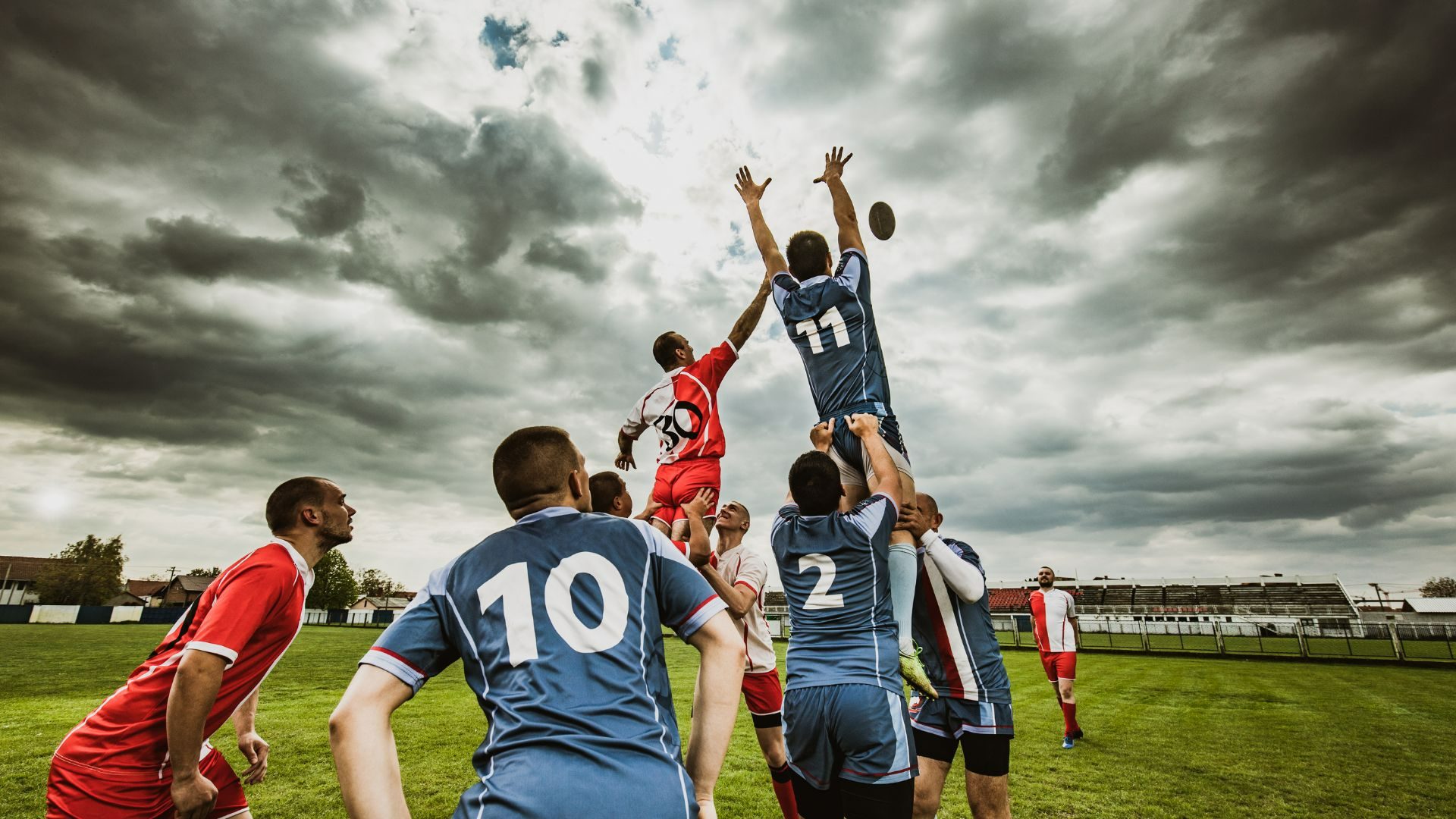 Touche de rugby disputée sous un ciel d'orage, performance et engagement